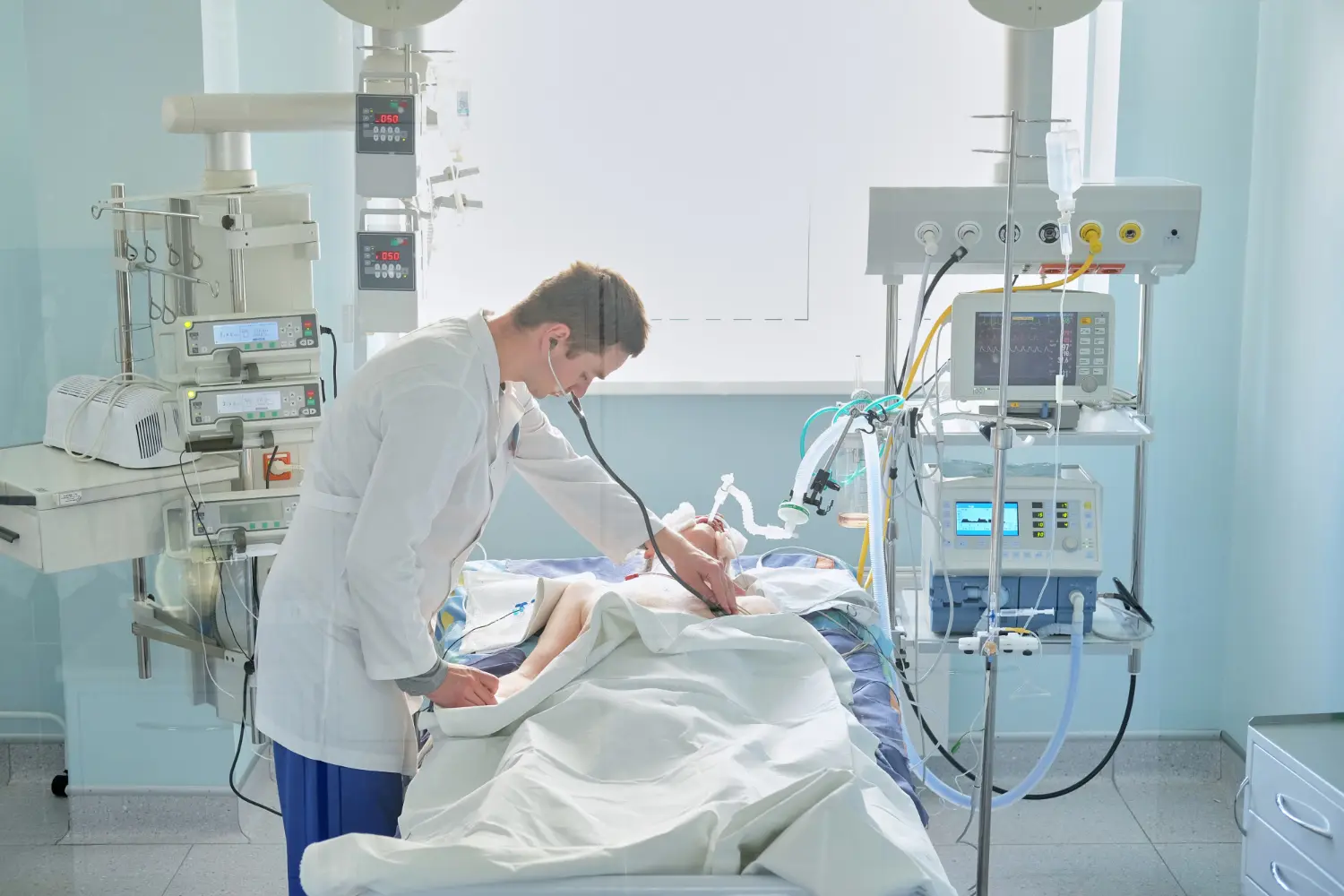 Arzt überwacht beatmeten Patienten auf Intensivstation – professionelle Beatmungspflege mit moderner Medizintechnik.